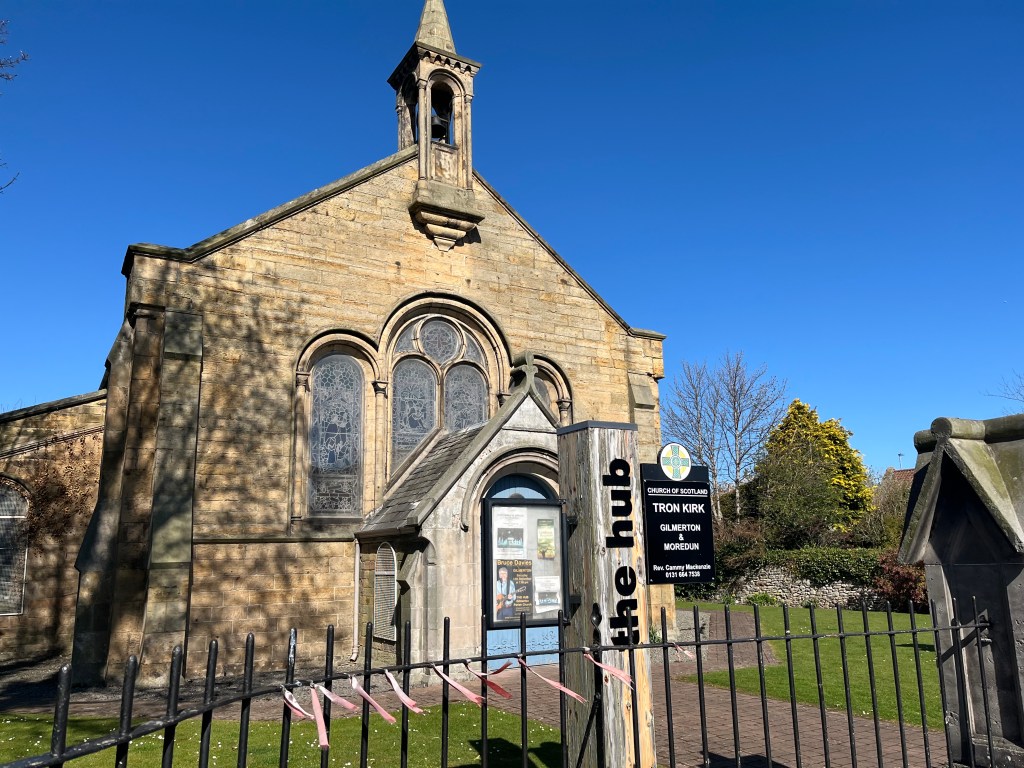 The Parish Church, Gilmerton on a sunny day with grass and a fence in the foreground.